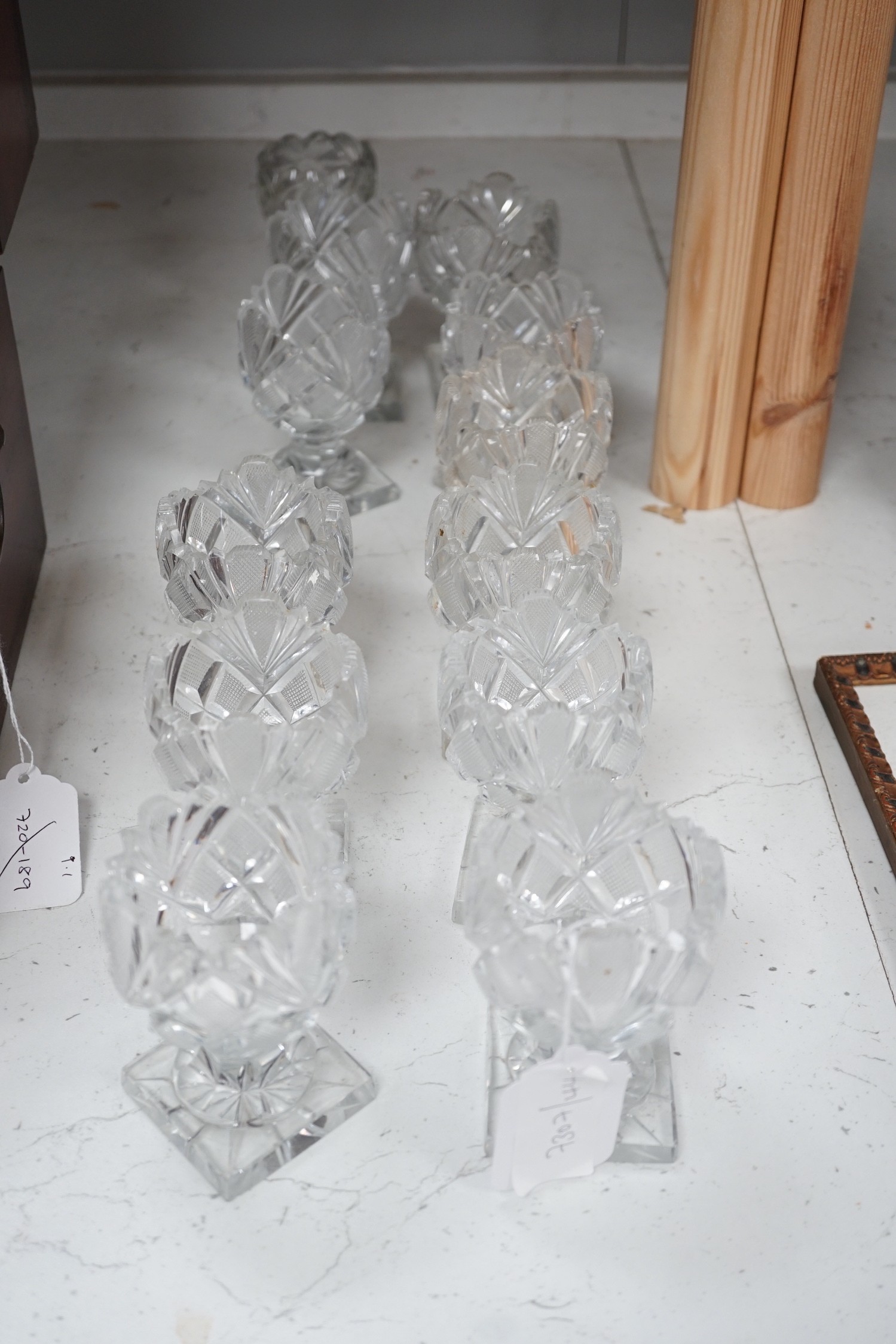 A set of twelve Victorian square base cut glass salts and four other 19th century clear glass salts.